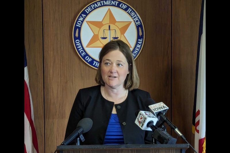 Iowa Attorney General Brenna Bird standing at a podium in her office while explaining the results of the audit, including resuming payments for emergency contraceptives but not abortion