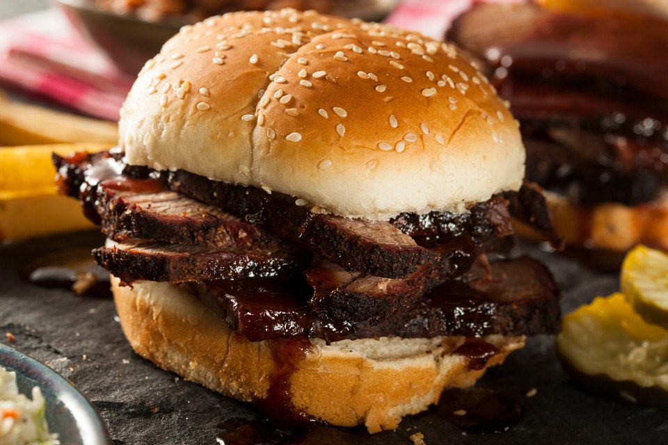 A brisket sandwich on a sesame seed bun.