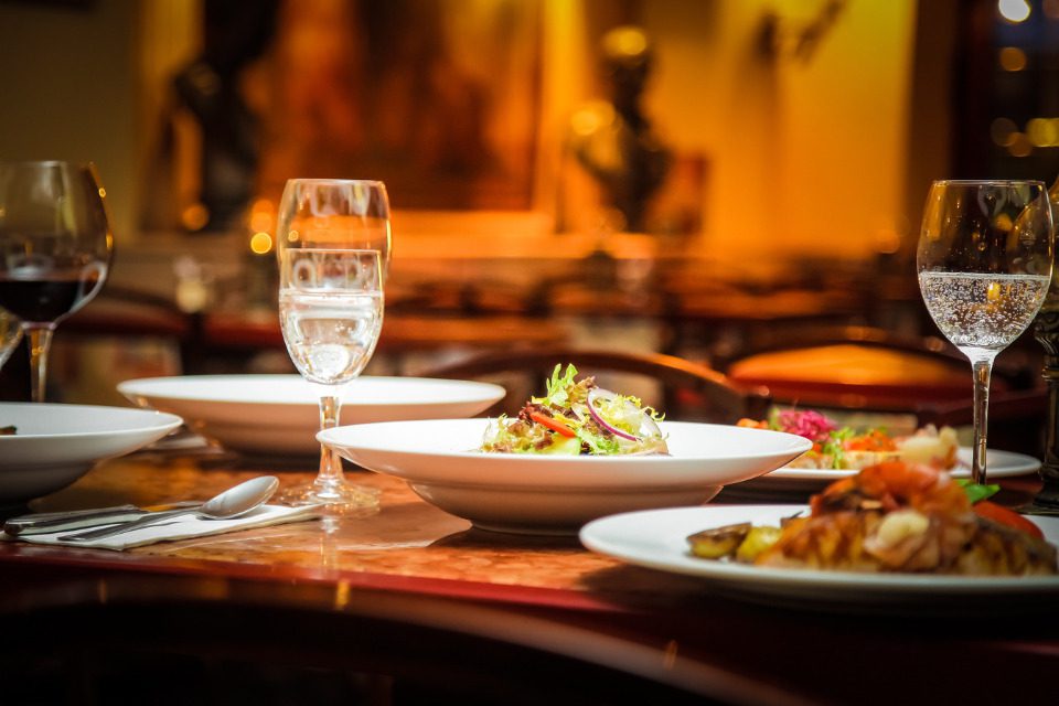 A table at a restaurant with sizzling dishes and champagne.
