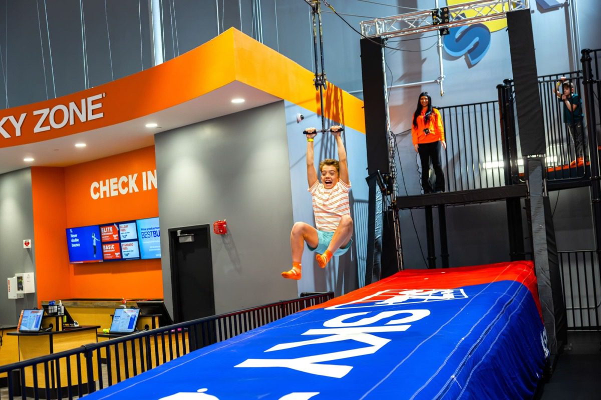 a kid riding an indoor zipline