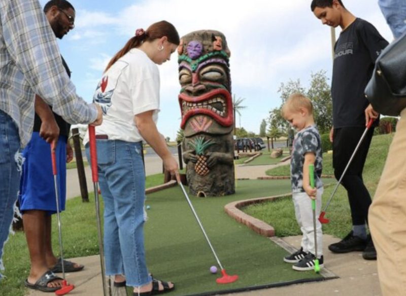 people enjouing Lost Island’s mini golf course